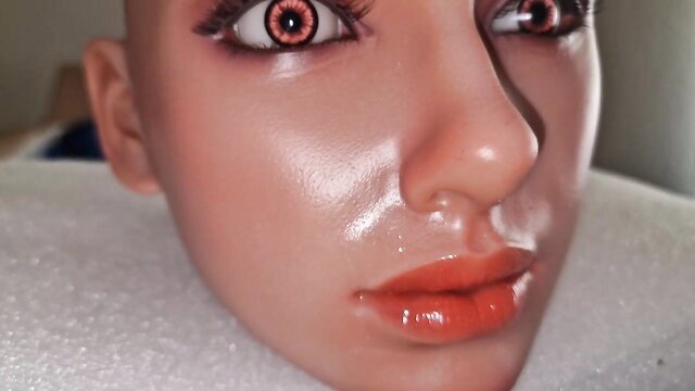 Closeup of super realistic silicone sex doll head with red eyes and glossy lips