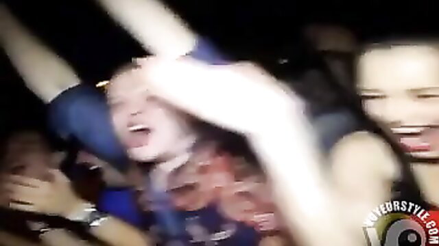 Topless party girl dances wildly on bar at crowded rave