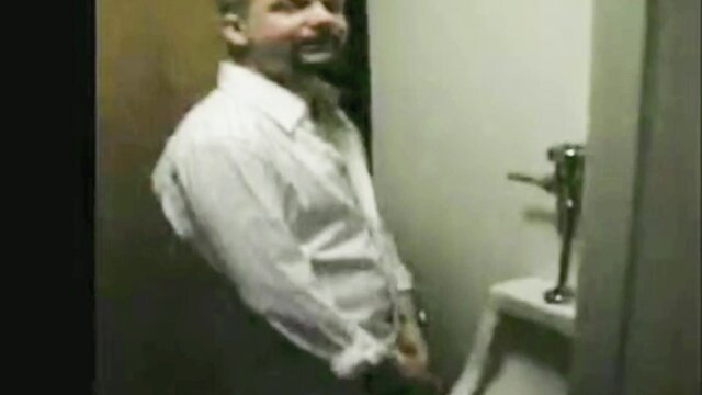 Man in white shirt at urinal, willingly molested by gay couple post-pee