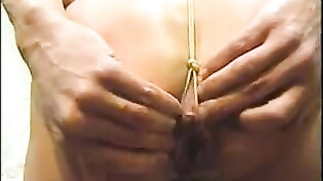 Closeup of woman bound with rope, hands spreading ass and pussy