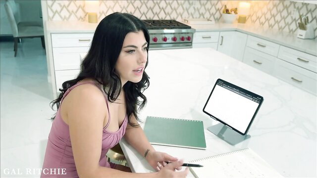 Brunette beauty in pink tank top at kitchen counter, teasing sexology lesson