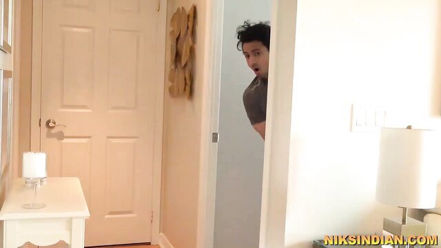 Indian stepmom peeking from door as stepson approaches