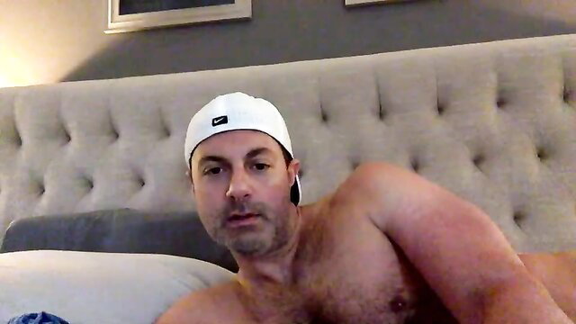 Muscular hairy dad in white cap shirtless on bed huge cock tease
