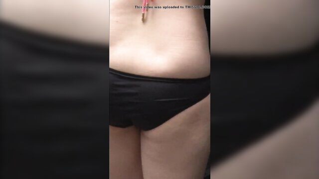 Slim Asian girl outdoor closeup of black swimsuit bottom and navel piercing