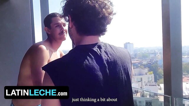Nude Latino guy chats with roommate by window in raw gay hookup