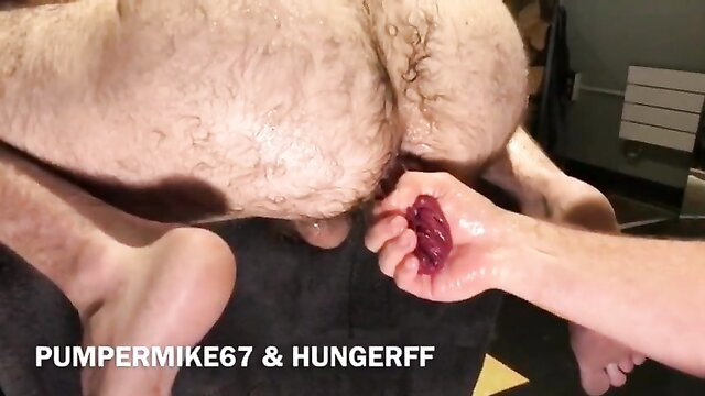 Hairy man holds out large anal prolapse in extreme gay fetish closeup