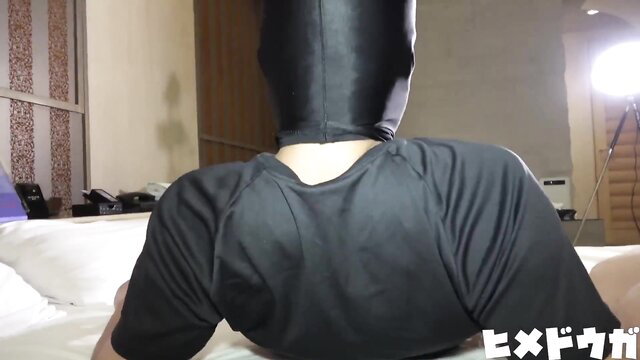 Asian woman in latex hood mask kneels on bed in tight black top, amateur JAV solo tease