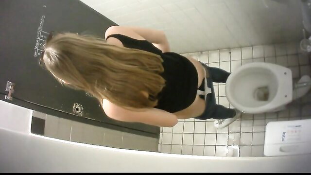 Slim long-haired brunette squatting over toilet taking a whiz in restroom