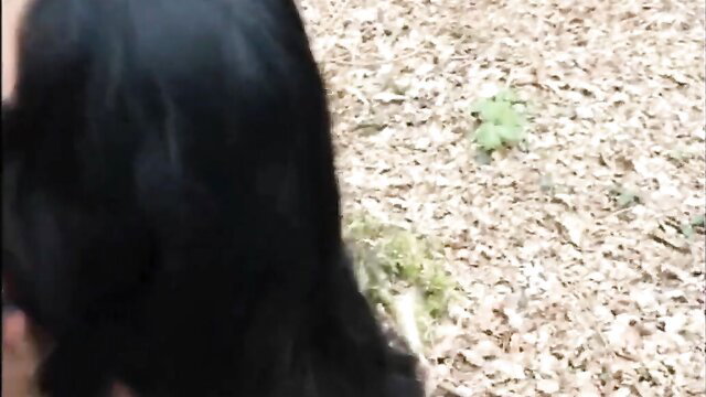 Mature black-haired wife kneels outdoors near green goo in amateur blowjob thumbnail