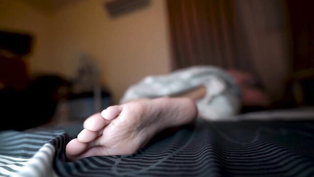 Closeup of sexy Chinese girl's bare foot on bed, foot fetish tease