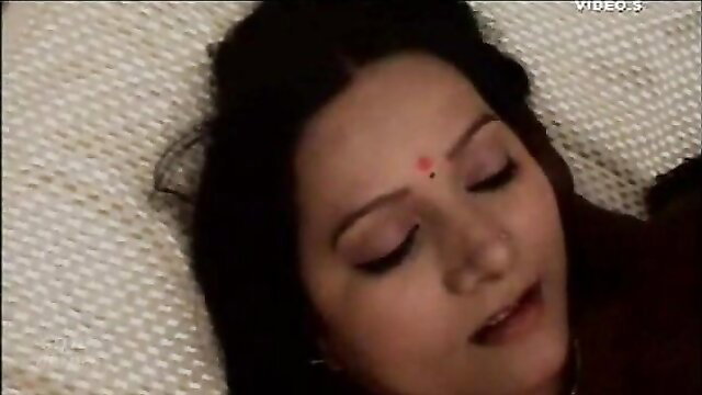 Big boob Desi aunty lying on bed with bindi, softcore tease