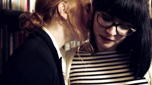 Two hot lesbians kissing intimately in library, glasses and striped top