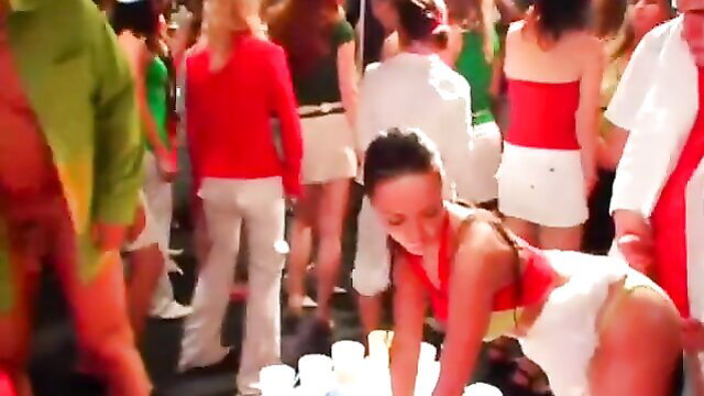 Brunette in red top and diaper bends over at crowded sex club party