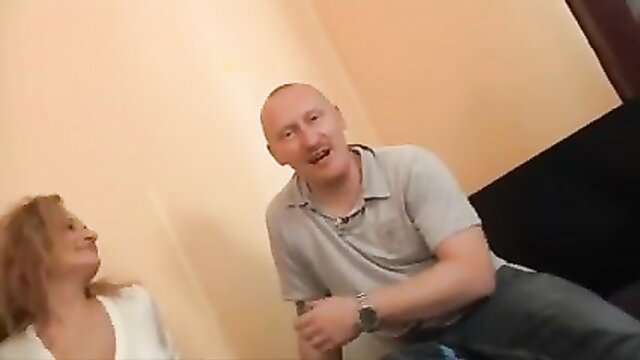 Bald dude watches mature blonde get fucked by friend on couch