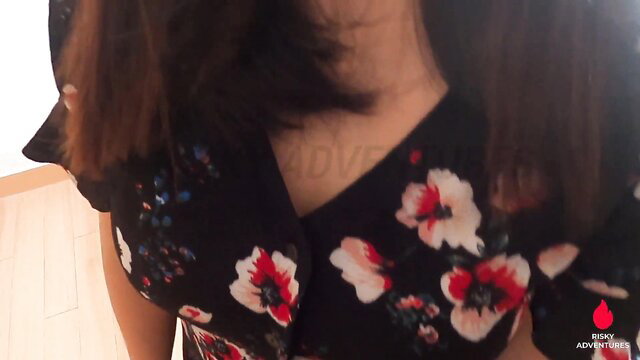 Woman in floral dress with tattoo, possibly in a bedroom