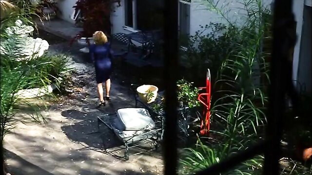Shannon Whirry in tight blue dress walks in garden, Lying in Wait