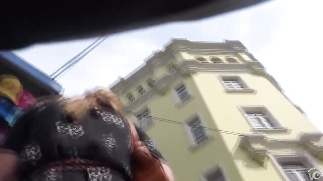 Blonde woman in floral summer skirt flashing upskirt outdoors near yellow building