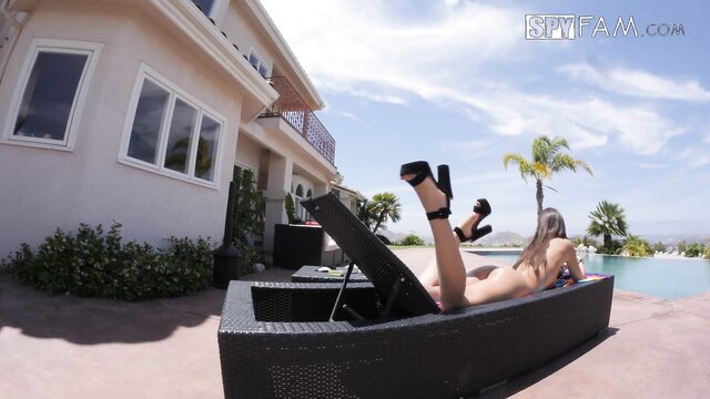 Blonde step-sis in thong bikini lounging poolside with high heels up