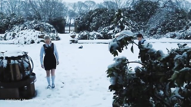 Blonde schoolgirl in uniform walks sexy in snowy garden, upskirt tease