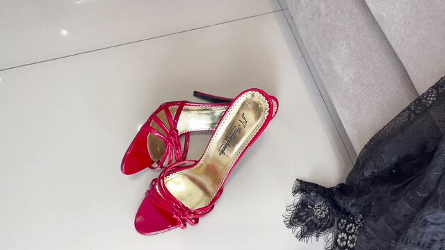 Sexy red strappy high heels with black lace lingerie on couch