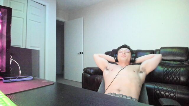 Shirtless Asian daddy relaxing topless in gaming chair, gay amateur thumbnail