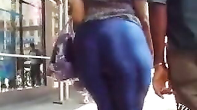Latina with gigantic booty in tight blue pants walking city streets
