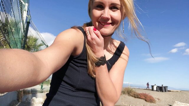 Ivi Roses applying lipstick on sunny beach, tank top tease
