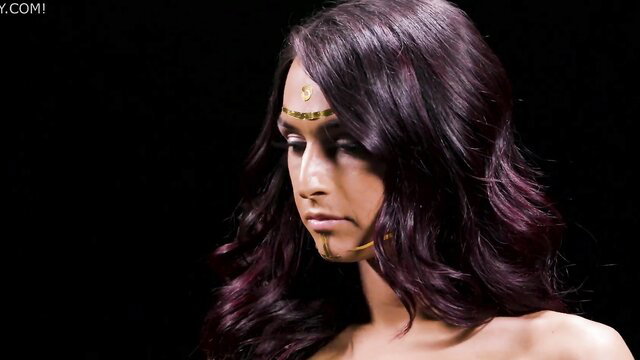 Stunning Adriana Chechik with purple hair and gold face paint in seductive pose