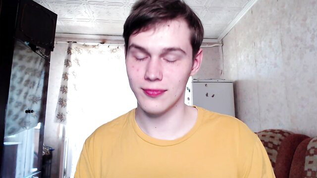 Young pale twink in yellow shirt with glossy pink lips, eyes closed