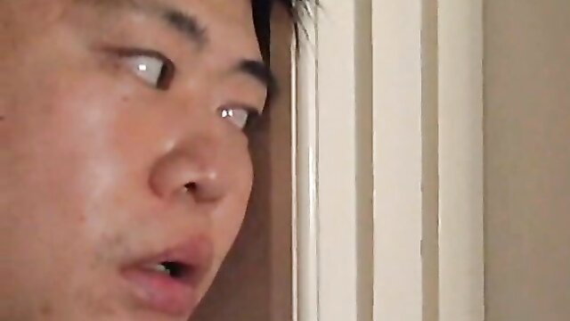 Closeup of surprised Asian man's face peeking from door in JAV houseboy scene