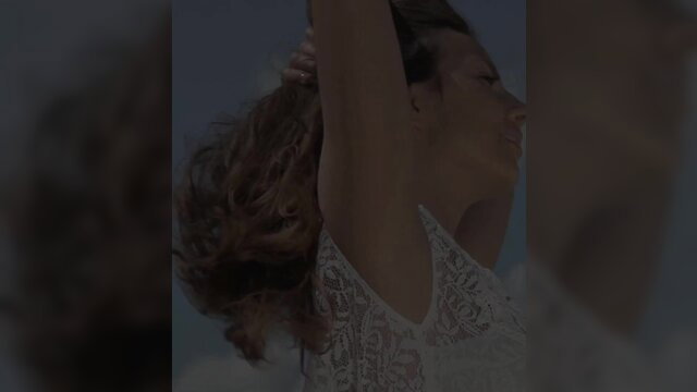 Connie Carter in sexy lace top, brunette hair flowing outdoors