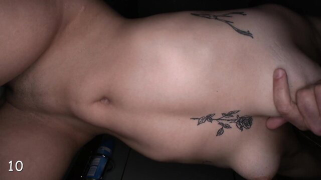 Slim nude Asian woman side pose with rose tattoo, hand on hip and breast