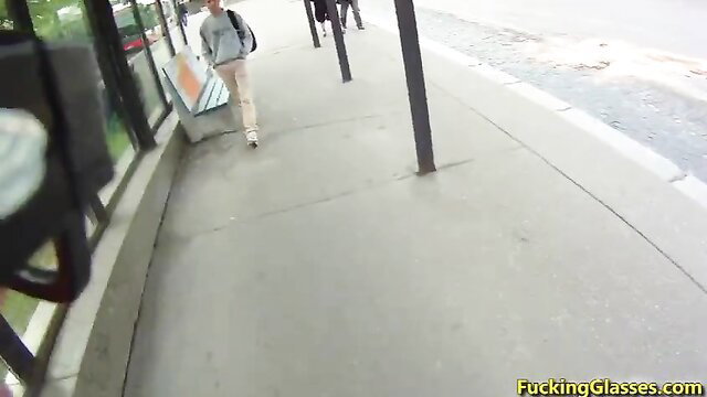 Slim white girl in tight chinos and backpack walks by bus stop outdoor