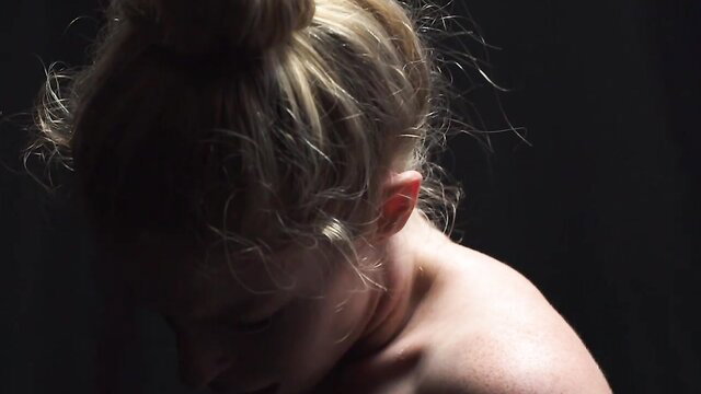 Blonde Mormon girl with messy bun, dramatic shadow profile closeup