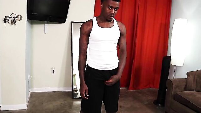 Sexy black beefcake Marquis in tank top and shorts grabs crotch