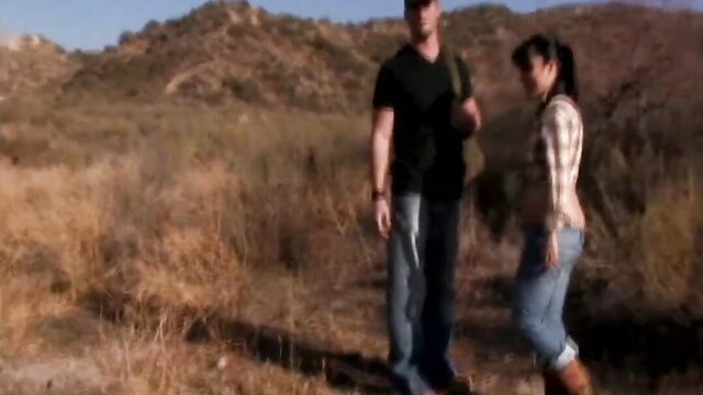 Hot Asian MILF in plaid shirt and jeans with buff guy outdoors