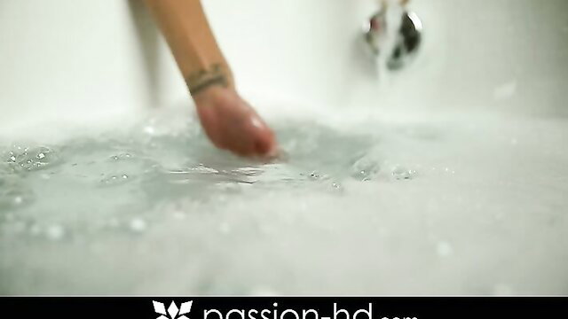 Chloe Amour's tattooed hand in steamy bubble bath tub