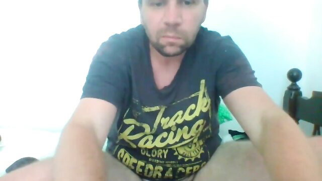 Bearded man in track racing tee spreads legs on cam, amateur solo tease