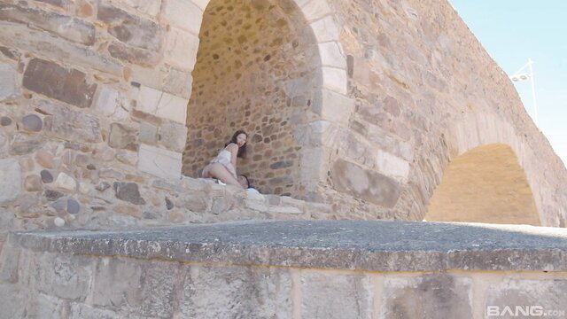 Sexy amateur Kity Hot sits teasingly in stone archway outdoors