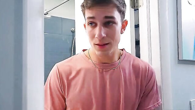 Young handsome guy in pink tee smirking in bathroom, stepmom taboo vibe