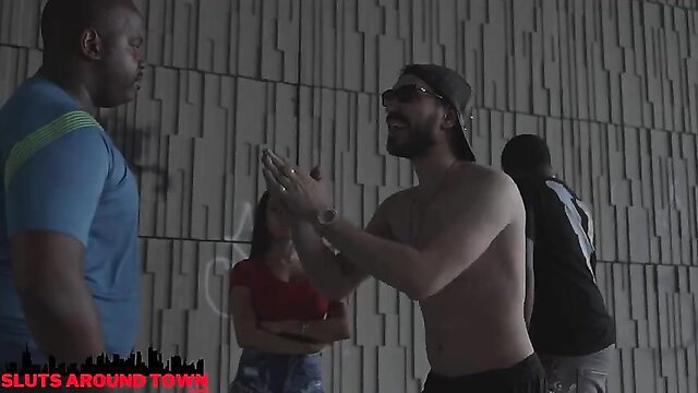 Muscular shirtless rapper high-fives black dude in skimpy group scene