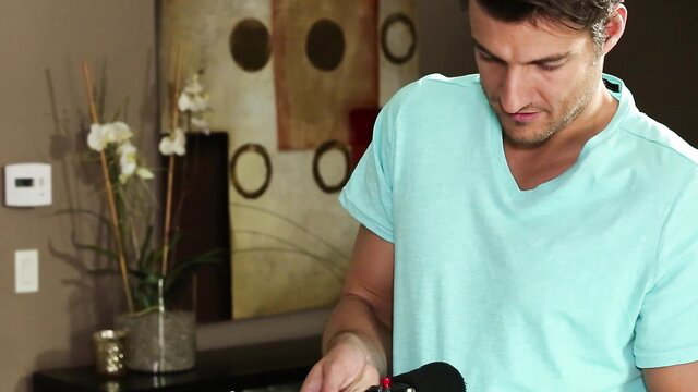 Handsome man in cyan V-neck shirt holding red toy in massage scene