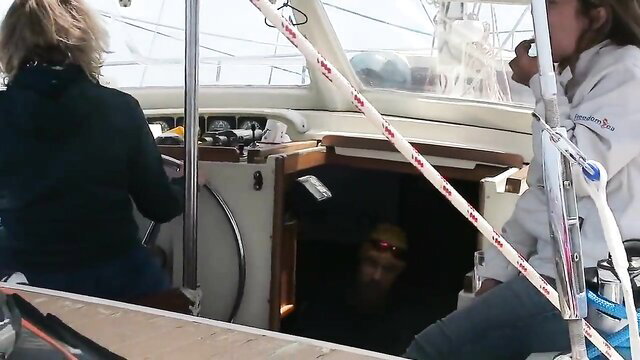 Blonde women on yacht with man emerging from cabin in adult video thumbnail