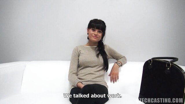 European amateur brunette in sweater sits casually on couch