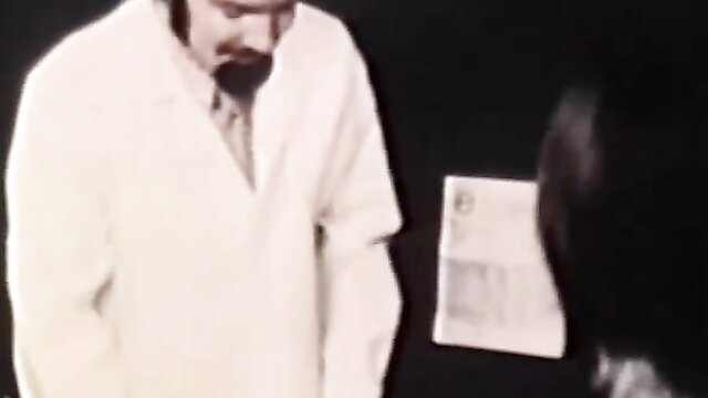Vintage doctor in lab coat examines brunette patient's back, Moon Films 707