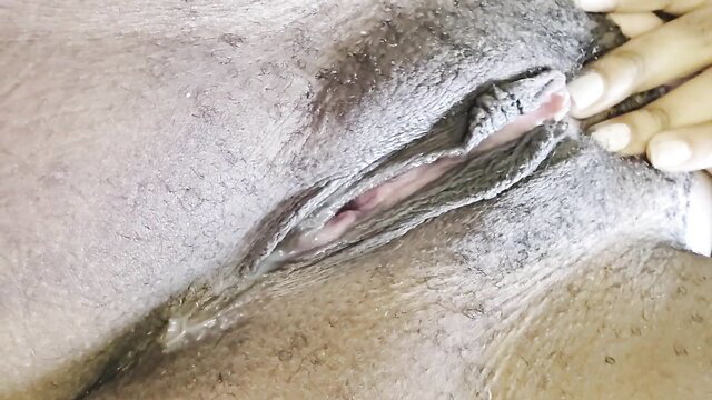 Closeup of woman milking wet hairy pussy with fingers in free HD video