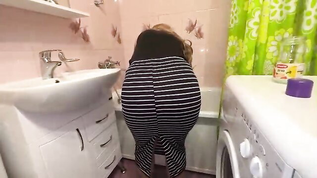 Blonde cougar in striped skirt bending over toilet in bathroom