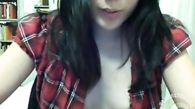 Cute Asian girl unbuttons plaid shirt exposing cleavage in library