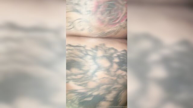Closeup of woman's huge tattooed tits with roses and swirls