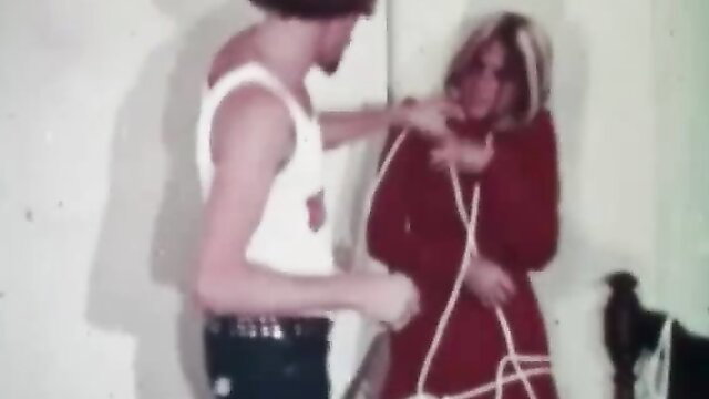 John Holmes ties up blonde babe in red dress, vintage BDSM scene